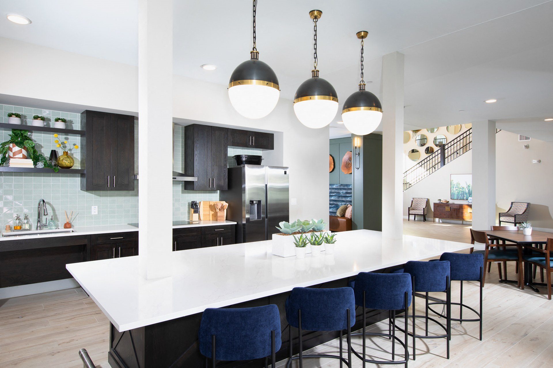 a communal kitchen with an island with seating at a senior apartment community